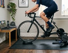 High-density bike trainer mat placed under a direct-drive turbo trainer in a small apartment workout space